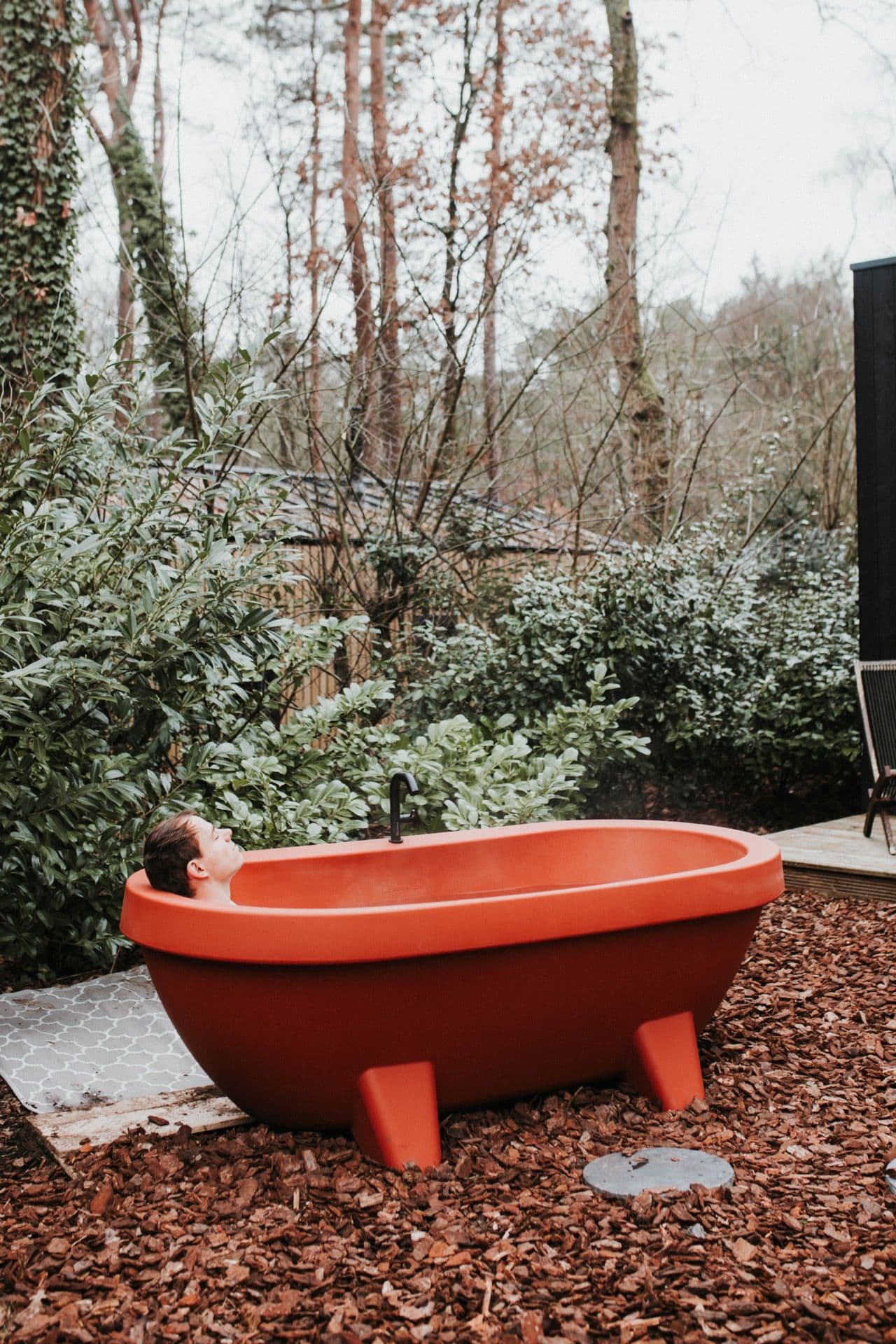 Outdoor spa bathtub with forest view at MIYO Tiny House Veluwe